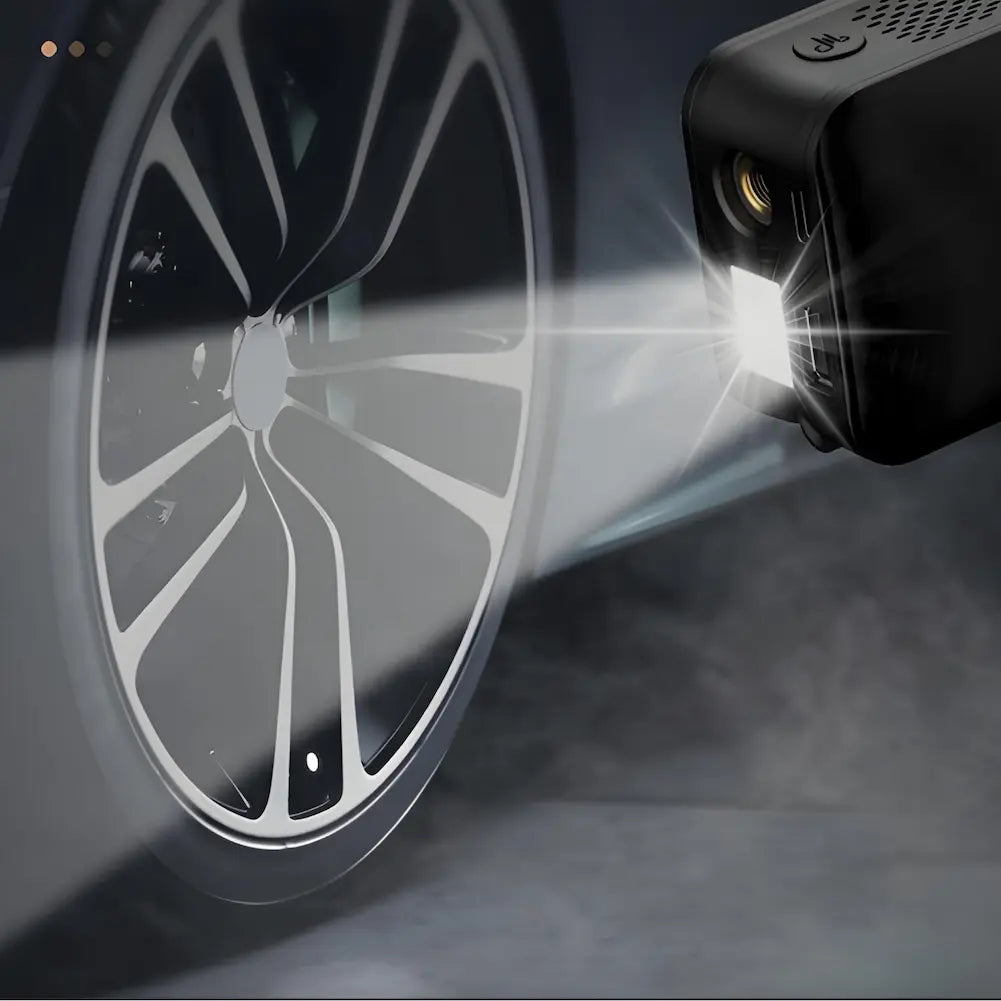 A imagem mostra um inflador de pneus portátil com a lanterna acesa, iluminando a roda de um carro. A luz branca e intensa destaca os detalhes do aro da roda, enfatizando a utilidade do inflador em situações de pouca visibilidade.
